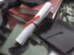 Books, diploma with a red ribbon, and graduation caps 